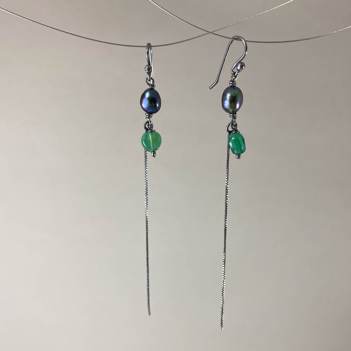 Brinco com gancho anzol, pedra ágata verde e pérola negra. Corrente veneziana 925 oxidada (escura) 6 cm. Embalagem em envelope de tecido, com cartão postal Amor Maior. Esta é uma joia de prata 925 produzida com uma liga conhecida internacionalmente com STERLING SILVER – 925, o que significa que ela é constituída de 92,5% de prata pura, garantindo a qualidade do material utilizado. Por se tratar de pedras naturais, podem apresentar variações na coloração.