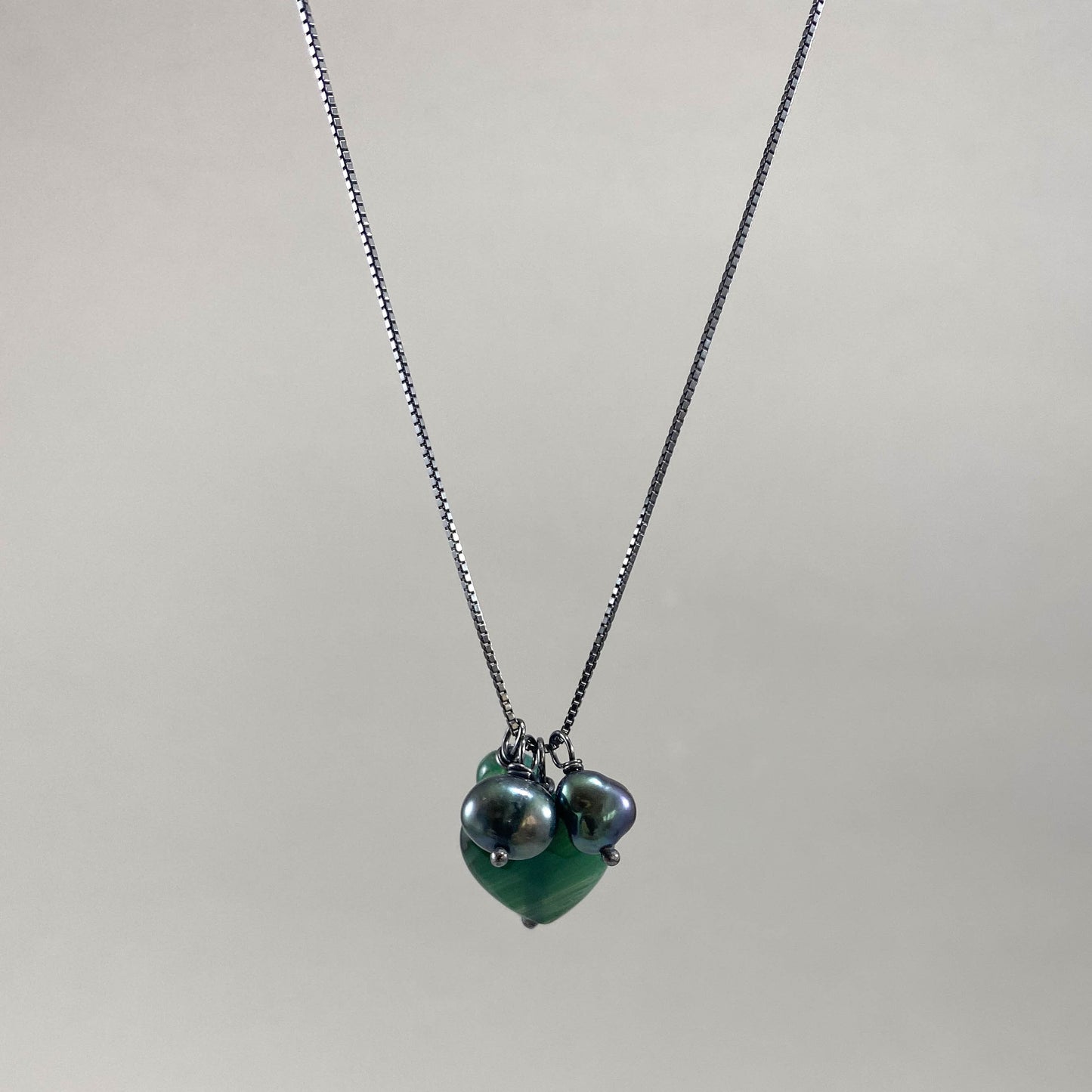 Colar corrente veneziana prata 925 oxidada (escura), com pingentes em pedras ágata verde e pérola negra. Comprimento: 70cm. Embalagem em envelope de tecido, com cartão postal Amor Maior. Esta é uma joia de prata 925 produzida com uma liga conhecida internacionalmente com STERLING SILVER – 925, o que significa que ela é constituída de 92,5% de prata pura, garantindo a qualidade do material utilizado. Por se tratar de pedras naturais, podem apresentar variações na coloração.