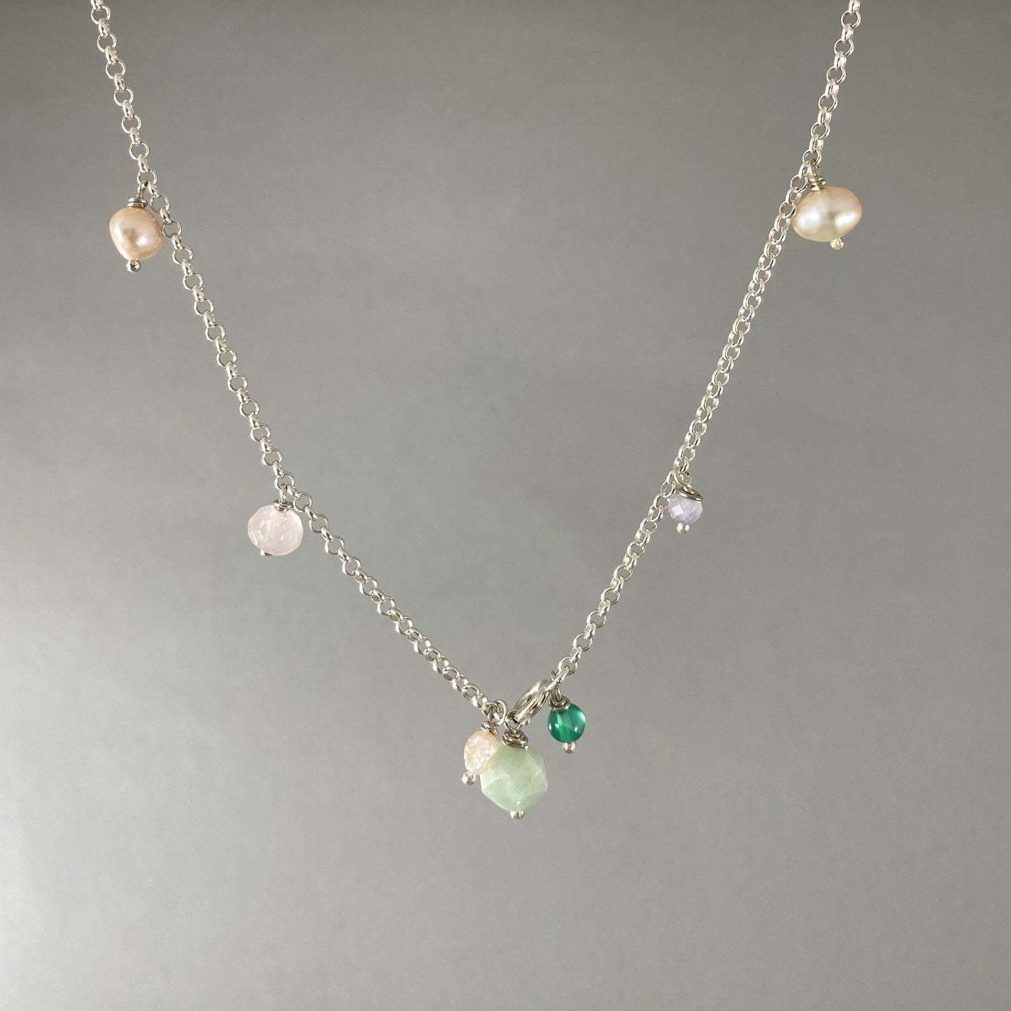 Colar em corrente elo português em prata 925 polida (clara), com pedras amazonita, quartzo rosa, pérola, ametista e ágata verde. Comprimento: 39 cm. Embalagem de algodão Santacosta. Esta é uma joia de prata 925 produzida com uma liga conhecida internacionalmente com STERLING SILVER – 925, o que significa que ela é constituída de 92,5% de prata pura, garantindo a qualidade do material utilizado. Por se tratar de pedras naturais, podem apresentar variações na coloração.