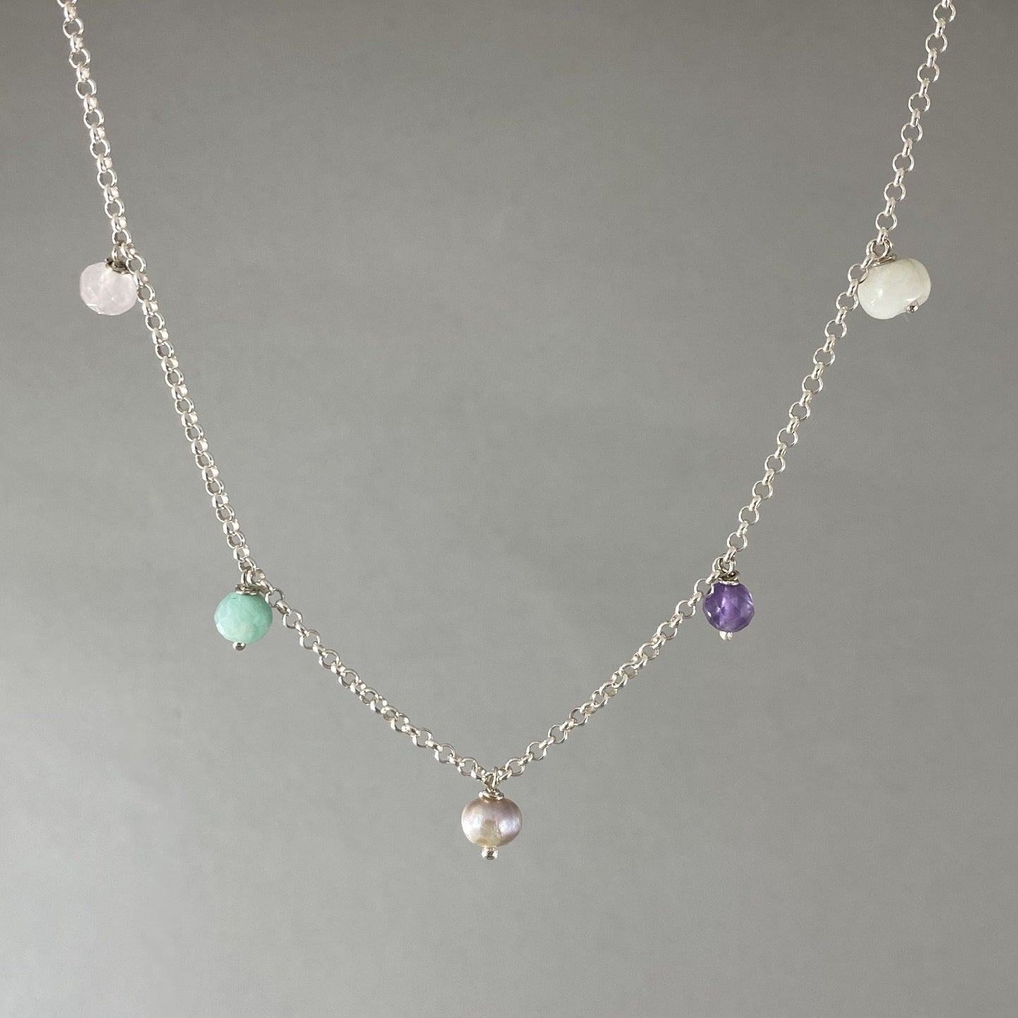 Colar em corrente elo português em prata 925 polida (clara), com pedras amazonita, quartzo rosa, pérola, ametista e ágata verde. Comprimento: 39 cm. Embalagem de algodão Santacosta. Esta é uma joia de prata 925 produzida com uma liga conhecida internacionalmente com STERLING SILVER – 925, o que significa que ela é constituída de 92,5% de prata pura, garantindo a qualidade do material utilizado. Por se tratar de pedras naturais, podem apresentar variações na coloração.