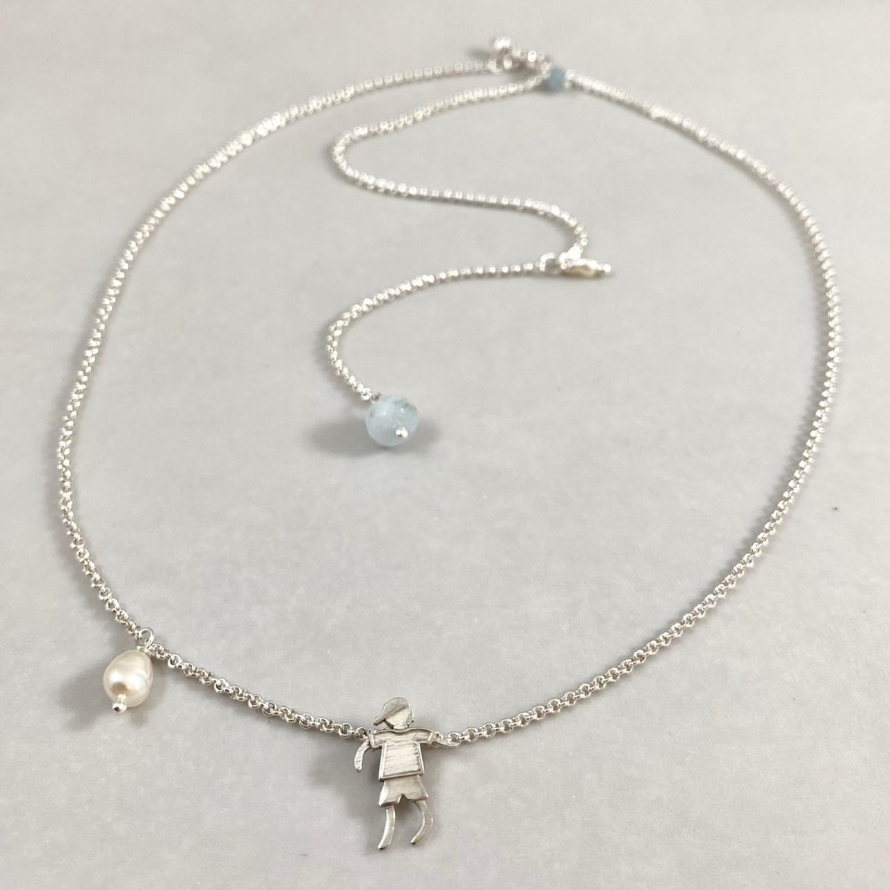 Colar corrente elo português mini prata 925 polida (clara), com pingente menino 14mm e detalhes em pérolas naturais e água marinha. Comprimento em três regulagens: 35cm, 45cm e 50cm. Embalagem em envelope de tecido, com cartão postal Amor Maior. Esta é uma joia de prata 925 produzida com uma liga conhecida internacionalmente com STERLING SILVER – 925, o que significa que ela é constituída de 92,5% de prata pura, garantindo a qualidade do material utilizado. Por se tratar de pedras naturais, podem apresentar