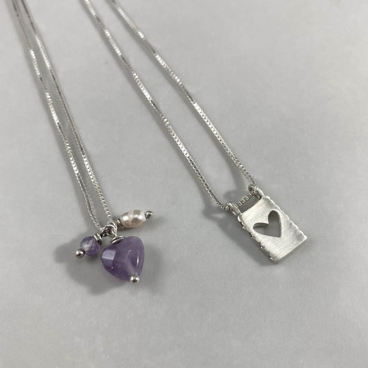 Colar corrente veneziana prata 925 polida (clara) com pingentes em pedras coração ametista, pérola rosa e placa coração vazado em prata 925 polida (clara). Comprimento: 70cm. Embalagem em envelope de tecido, com cartão postal Amor Maior. Esta é uma joia de prata 925 produzida com uma liga conhecida internacionalmente com STERLING SILVER – 925, o que significa que ela é constituída de 92,5% de prata pura, garantindo a qualidade do material utilizado. Por se tratar de pedras naturais, podem apresentar variaçõ