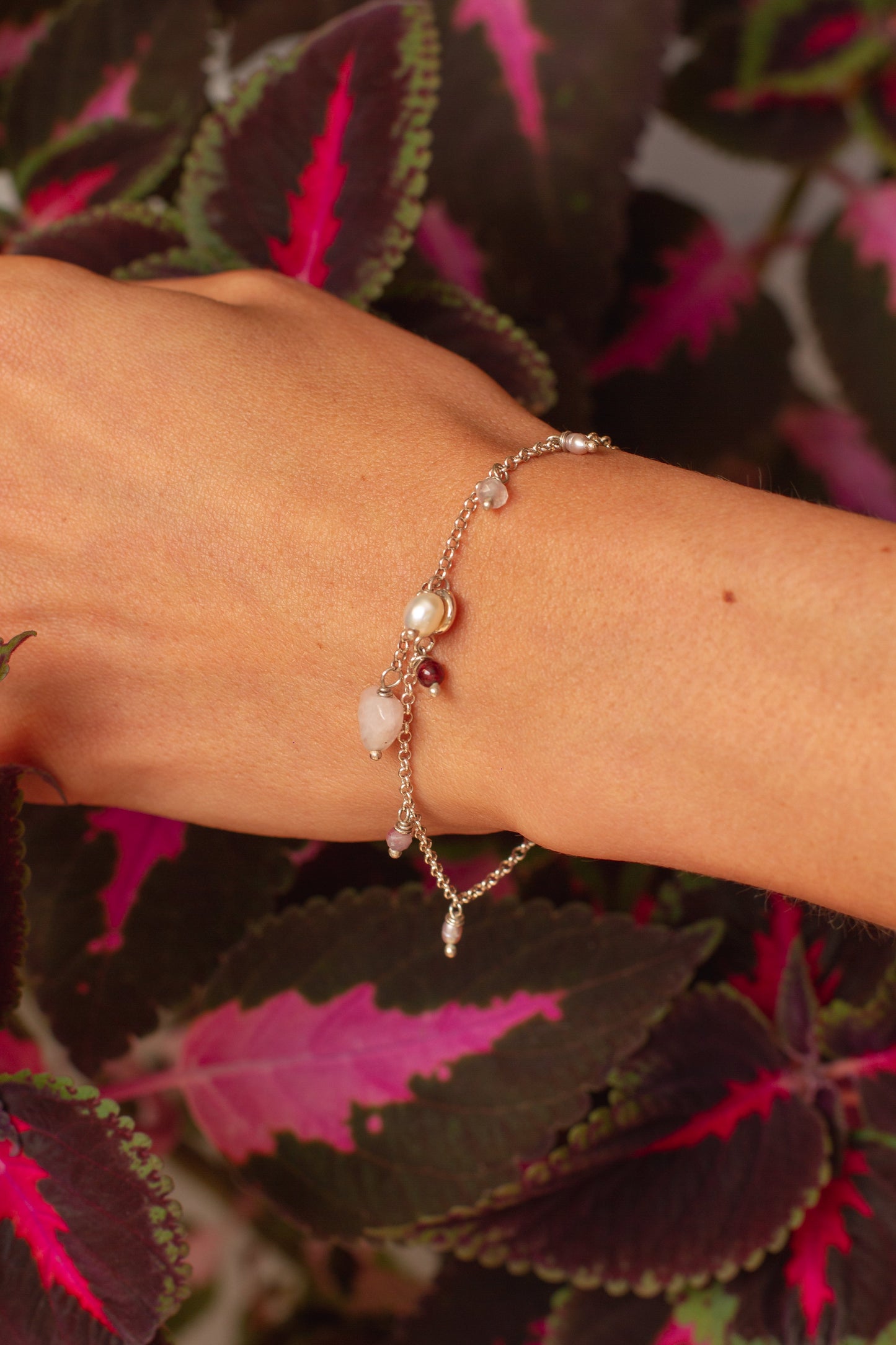 Pulseira corrente elo português aberto em prata 925 polida (clara), com pingentes em pedras quartzo rosa, pérola lilás, granada, quartzo cereja e rodocrosita. Comprimento: regulagem entre 15cm e 18cm. Para outras medidas entre em contato. Embalagem em envelope de tecido, com cartão postal Amor Maior. Esta é uma joia de prata 925 produzida com uma liga conhecida internacionalmente com STERLING SILVER – 925, o que significa que ela é constituída de 92,5% de prata pura, garantindo a qualidade do material utili