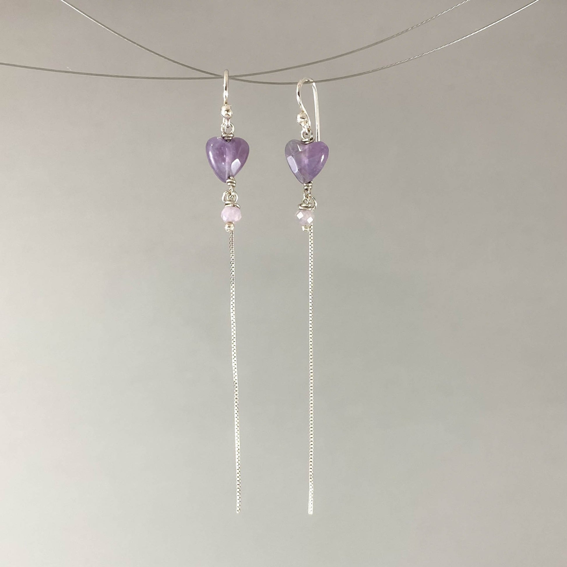 Brinco com gancho anzol, pedras coração ametista. Corrente veneziana 925 polida (clara) 6cm. Embalagem em envelope de tecido, com cartão postal Amor Maior. Esta é uma joia de prata 925 produzida com uma liga conhecida internacionalmente com STERLING SILVER – 925, o que significa que ela é constituída de 92,5% de prata pura, garantindo a qualidade do material utilizado. Por se tratar de pedras naturais, podem apresentar variações na coloração.