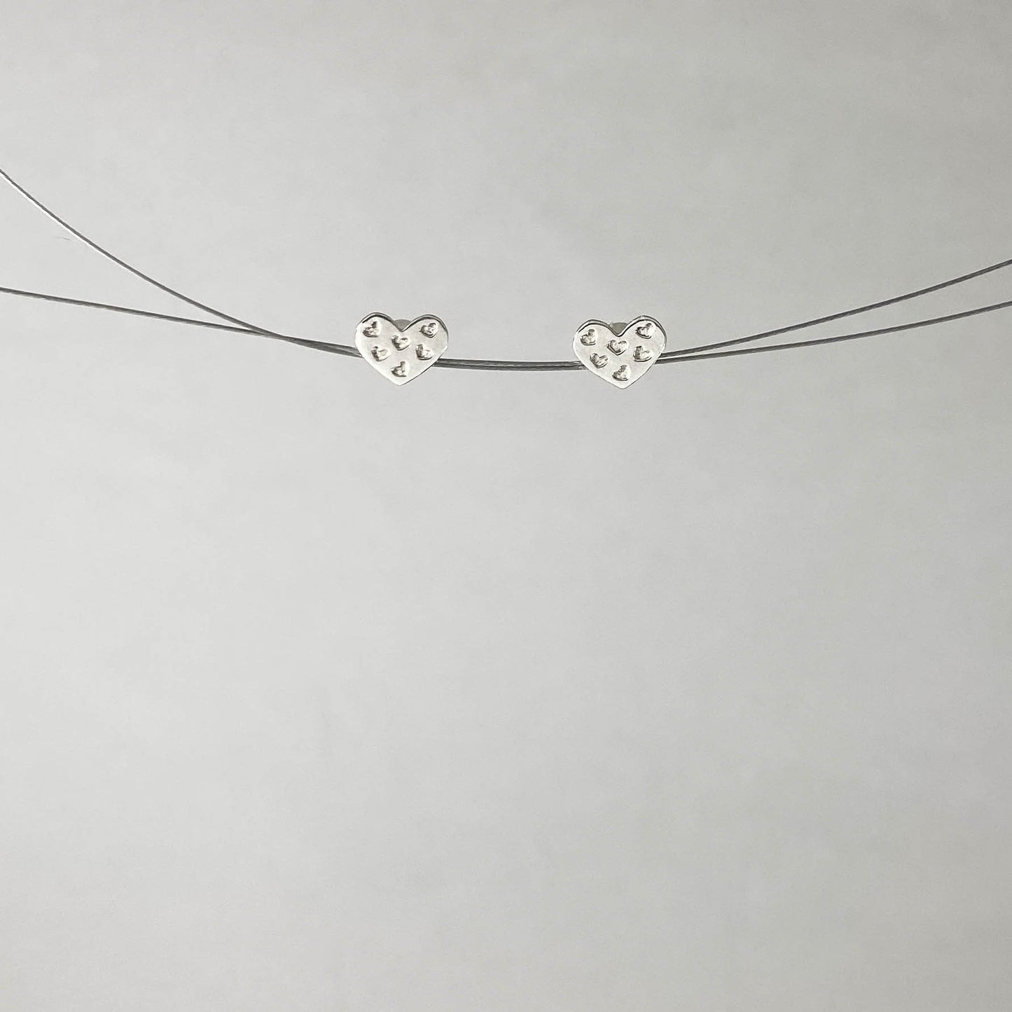 Brinco base em forma de coração com mini corações em prata 925 polida (clara). Embalagem em envelope de tecido, com cartão postal Amor Maior. Esta é uma joia de prata 925 produzida com uma liga conhecida internacionalmente com STERLING SILVER – 925, o que significa que ela é constituída de 92,5% de prata pura, garantindo a qualidade do material utilizado.