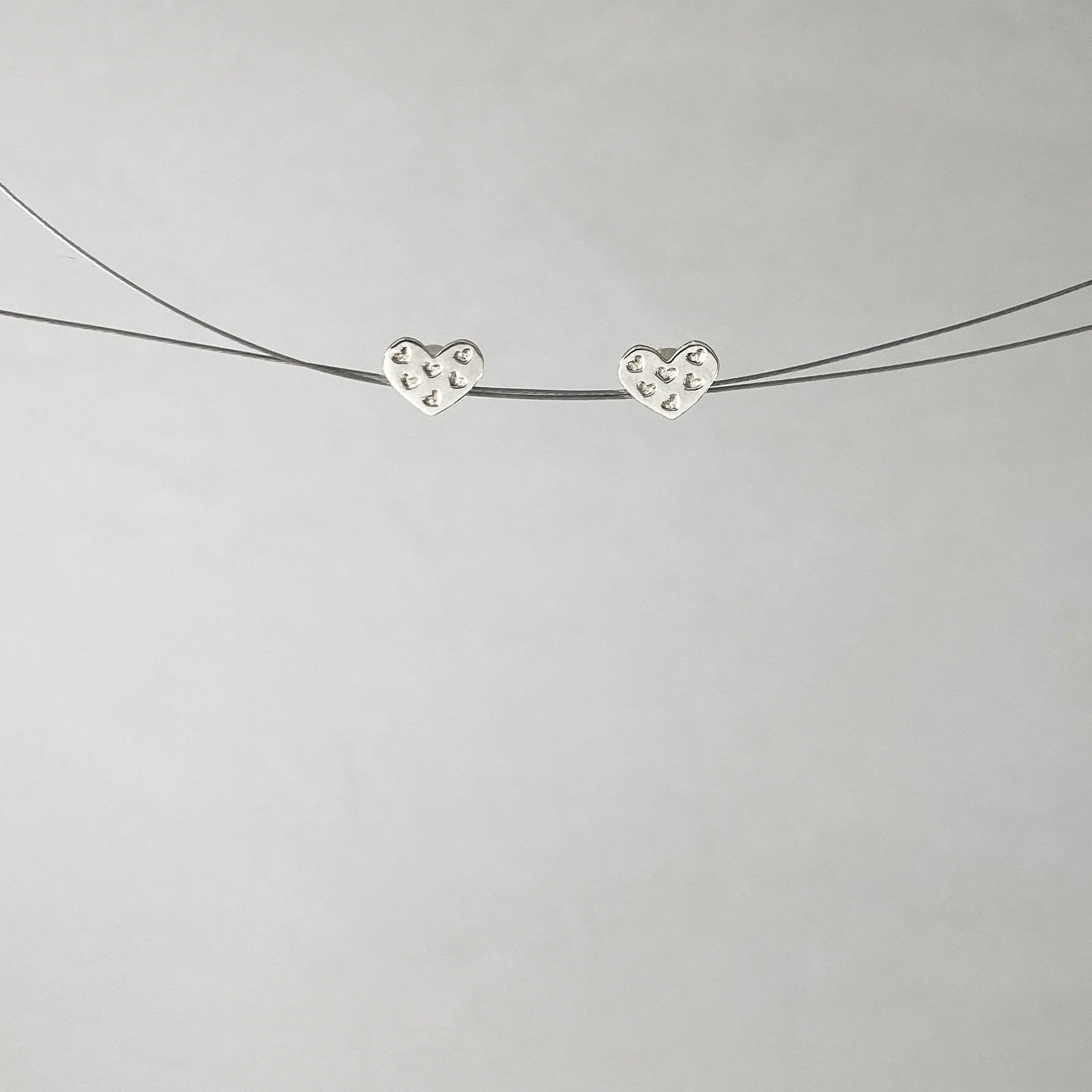 Brinco base em forma de coração com mini corações em prata 925 polida (clara). Embalagem em envelope de tecido, com cartão postal Amor Maior. Esta é uma joia de prata 925 produzida com uma liga conhecida internacionalmente com STERLING SILVER – 925, o que significa que ela é constituída de 92,5% de prata pura, garantindo a qualidade do material utilizado.