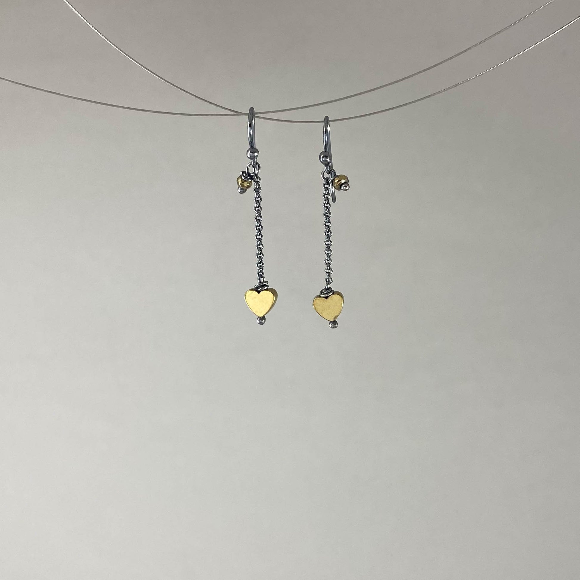 Brinco com gancho anzol, pedra hematita dourada. Corrente elo português 925 oxidada (escura) 2cm. Embalagem em envelope de tecido, com cartão postal Amor Maior. Esta é uma joia de prata 925 produzida com uma liga conhecida internacionalmente com STERLING SILVER – 925, o que significa que ela é constituída de 92,5% de prata pura, garantindo a qualidade do material utilizado. Por se tratar de pedras naturais, podem apresentar variações na coloração.