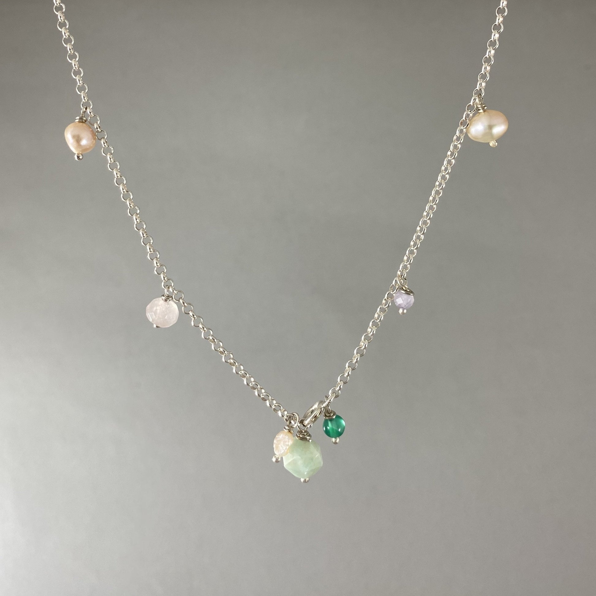 Colar em corrente elo português em prata 925 polida (clara), com pedras amazonita, quartzo rosa, pérola, ametista e ágata verde. Comprimento: 39 cm. Embalagem de algodão Santacosta. Esta é uma joia de prata 925 produzida com uma liga conhecida internacionalmente com STERLING SILVER – 925, o que significa que ela é constituída de 92,5% de prata pura, garantindo a qualidade do material utilizado. Por se tratar de pedras naturais, podem apresentar variações na coloração.