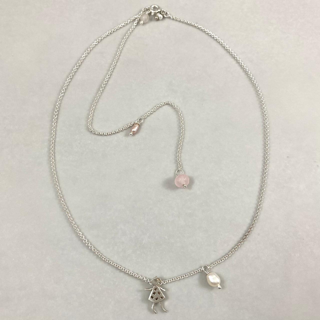 Colar corrente elo português mini prata 925 polida (clara), com pingente menina 14mm e detalhes em pedras pérolas e quartzo rosa. Comprimento em três regulagens: 35cm, 45cm e 50cm. Embalagem em envelope de tecido, com cartão postal Amor Maior. Esta é uma joia de prata 925 produzida com uma liga conhecida internacionalmente com STERLING SILVER – 925, o que significa que ela é constituída de 92,5% de prata pura, garantindo a qualidade do material utilizado. Por se tratar de pedras naturais, podem apresentar v