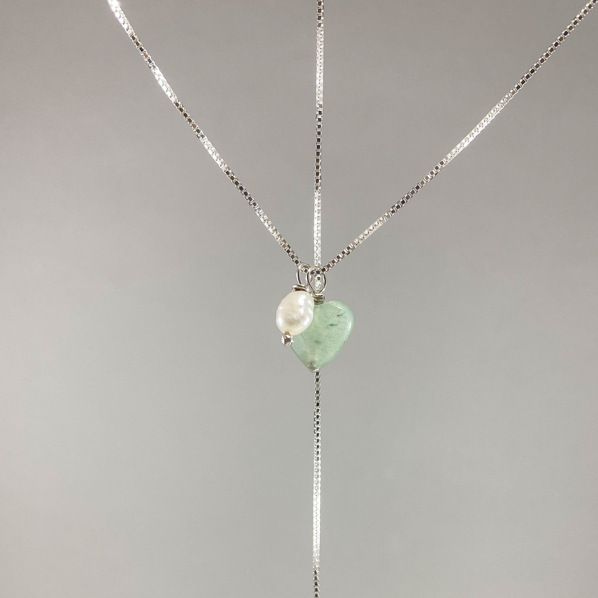 Colar corrente veneziana prata 925 polida (clara), com pingentes em pedras coração quartzo verde e pérola. Comprimento: 50cm. Embalagem em envelope de tecido, com cartão postal Amor Maior. Esta é uma joia de prata 925 produzida com uma liga conhecida internacionalmente com STERLING SILVER – 925, o que significa que ela é constituída de 92,5% de prata pura, garantindo a qualidade do material utilizado. Por se tratar de pedras naturais, podem apresentar variações na coloração.