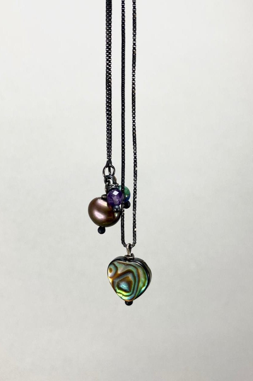 Colar corrente veneziana prata 925 oxidada (escura) com pingentes em pedras coração abalone, ametista, crisocola e pérola negra. Comprimento: 70cm. Embalagem em envelope de tecido, com cartão postal Amor Maior. Esta é uma joia de prata 925 produzida com uma liga conhecida internacionalmente com STERLING SILVER – 925, o que significa que ela é constituída de 92,5% de prata pura, garantindo a qualidade do material utilizado. Por se tratar de pedras naturais, podem apresentar variações na coloração.