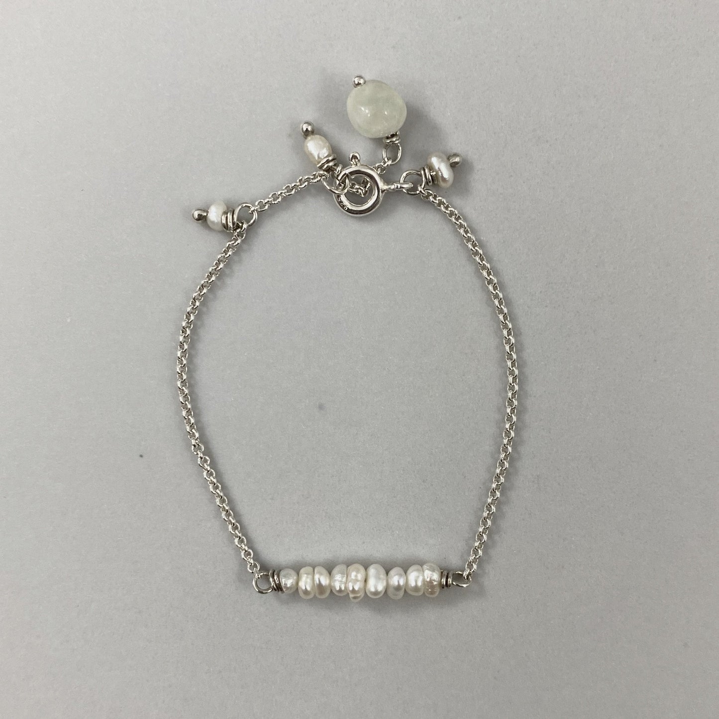 Pulseira corrente cartier em prata 925 polida (clara), com pedras pérola com água-marinha. Comprimento: regulagem entre 13cm e 15cm. Para outras medidas entre em contato. Embalagem de algodão Santacosta. Esta é uma joia de prata 925 produzida com uma liga conhecida internacionalmente com STERLING SILVER – 925, o que significa que ela é constituída de 92,5% de prata pura, garantindo a qualidade do material utilizado. Por se tratar de pedras naturais, podem apresentar variações na coloração.