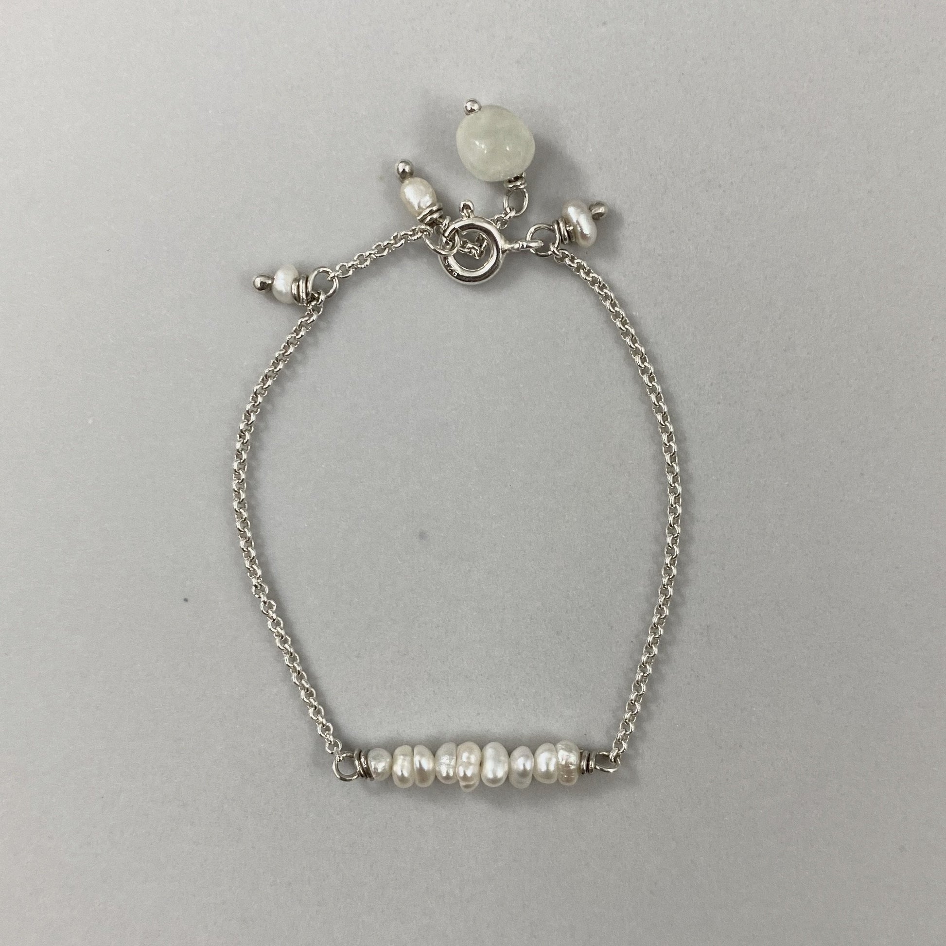 Pulseira corrente cartier em prata 925 polida (clara), com pedras pérola com água-marinha. Comprimento: regulagem entre 13cm e 15cm. Para outras medidas entre em contato. Embalagem de algodão Santacosta. Esta é uma joia de prata 925 produzida com uma liga conhecida internacionalmente com STERLING SILVER – 925, o que significa que ela é constituída de 92,5% de prata pura, garantindo a qualidade do material utilizado. Por se tratar de pedras naturais, podem apresentar variações na coloração.