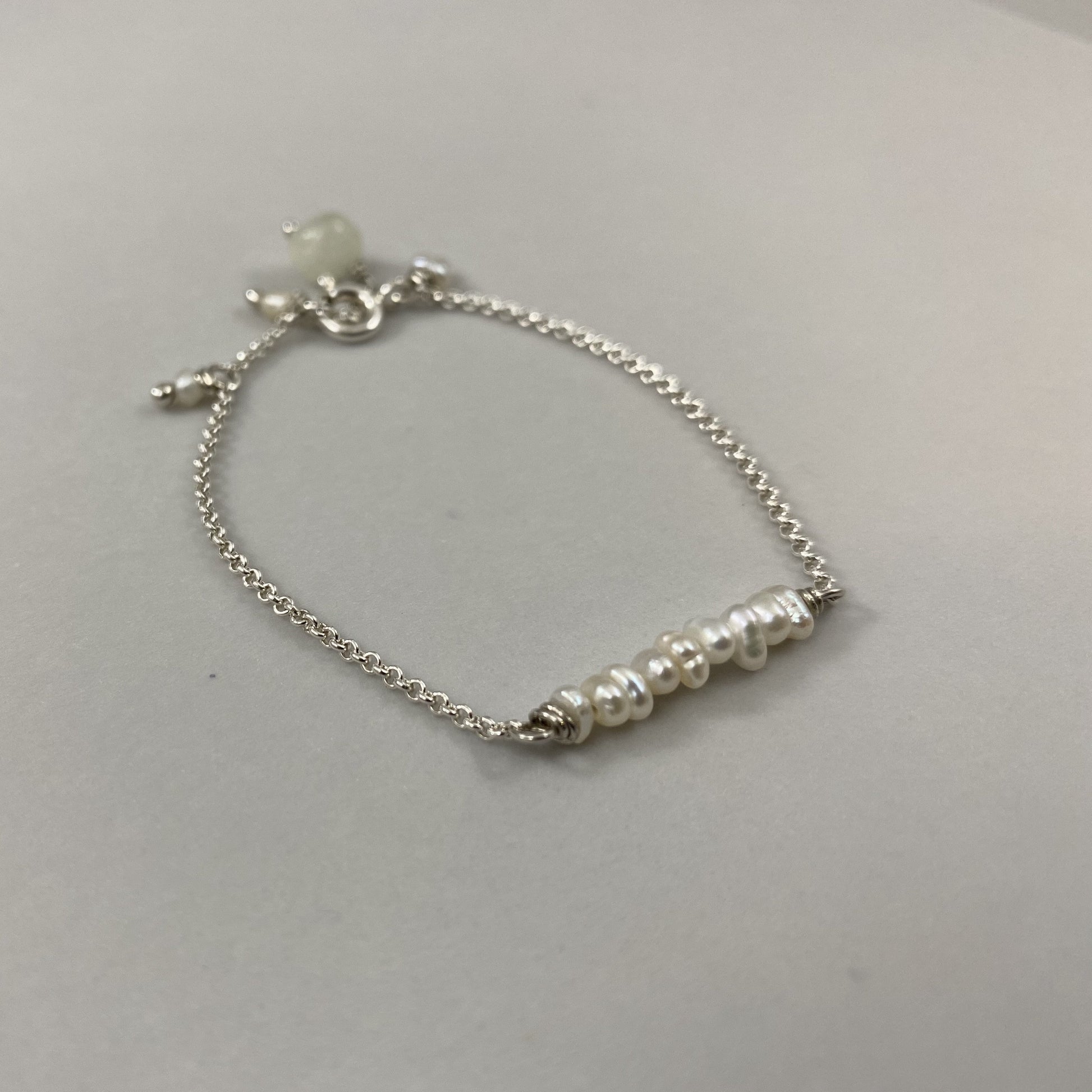 Pulseira corrente cartier em prata 925 polida (clara), com pedras pérola com água-marinha. Comprimento: regulagem entre 13cm e 15cm. Para outras medidas entre em contato. Embalagem de algodão Santacosta. Esta é uma joia de prata 925 produzida com uma liga conhecida internacionalmente com STERLING SILVER – 925, o que significa que ela é constituída de 92,5% de prata pura, garantindo a qualidade do material utilizado. Por se tratar de pedras naturais, podem apresentar variações na coloração.